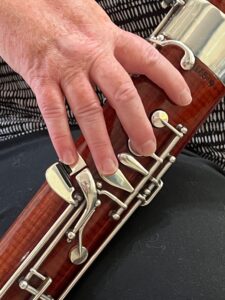 right-hand index, middle, ring, and pinky fingers in relaxed playing position on boot joint