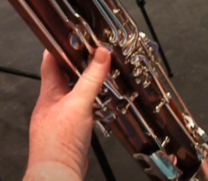 left thumb pressing low D, C, and B keys