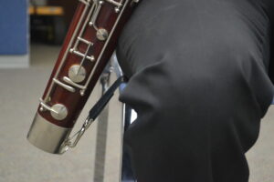 player allowing seat strap to support the weight of bassoon while playing